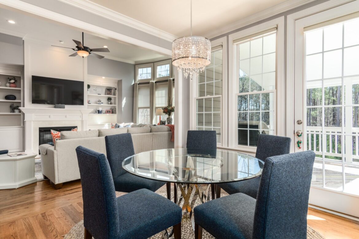 Kitchen setting with white cabinets, glass table and chairs. Home Maintenance, read the article at Betty Most Agency