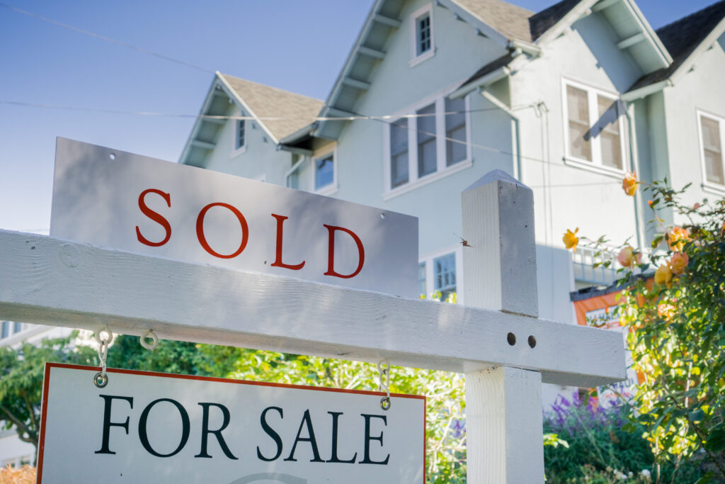 House with a sold sign in the front yard. 